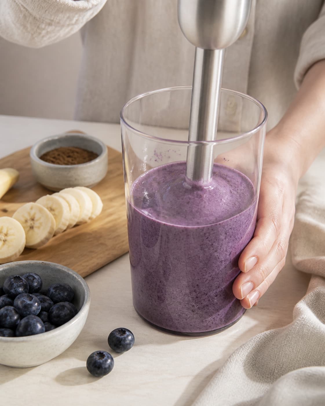 One single photorealistic instructional frame of the final colorful smoothie blending until thick and uniform for Blåbær og lakridssmoothie, featuring blåbær, banan, lakridspulver, with only the named equipment and no unrelated food, text, logos or packaging under tilberedningen af blåbær og lakridssmoothie