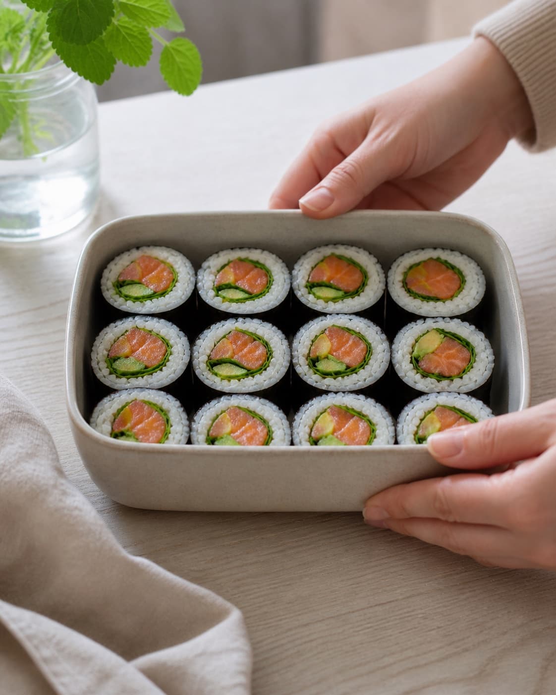 One single photorealistic instructional frame of clean maki pieces arranged in one lunch box for Maki sushi med koldrøget laks, featuring sushiris, nori, koldrøget laks, with only the named equipment and no unrelated food, text, logos or packaging under tilberedningen af maki sushi med koldrøget laks