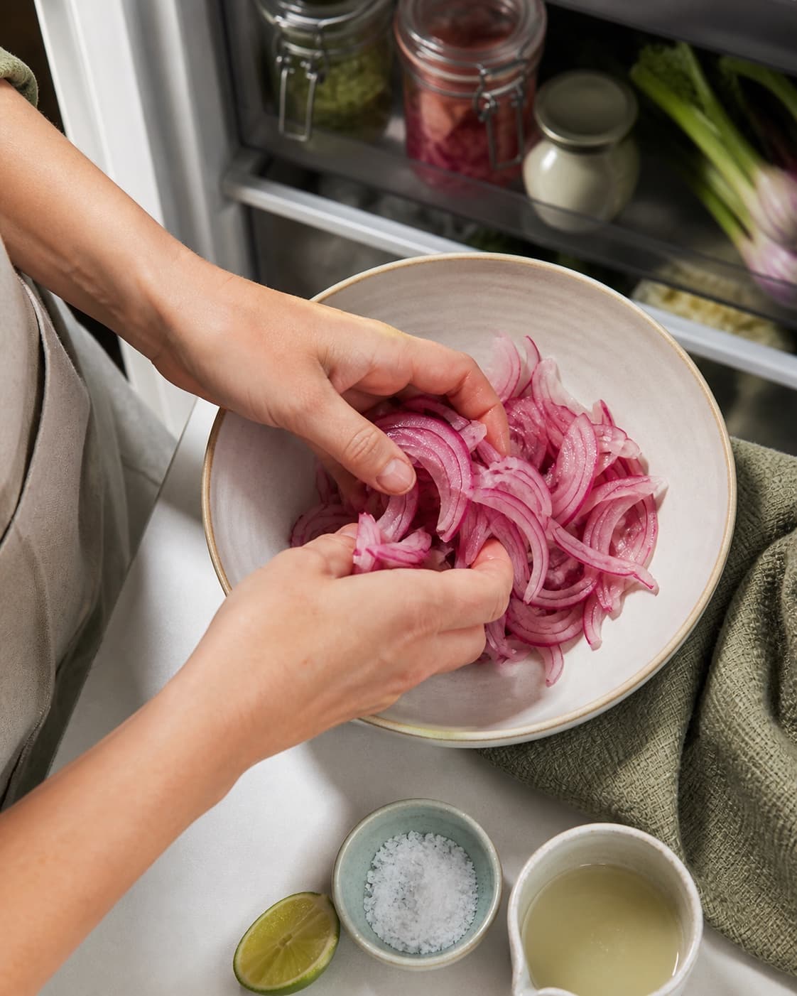 Tynde rødløgsbåde masseres med lime, sukker og salt i en ren skål, til de er klart rosa, bøjelige og stadig sprøde