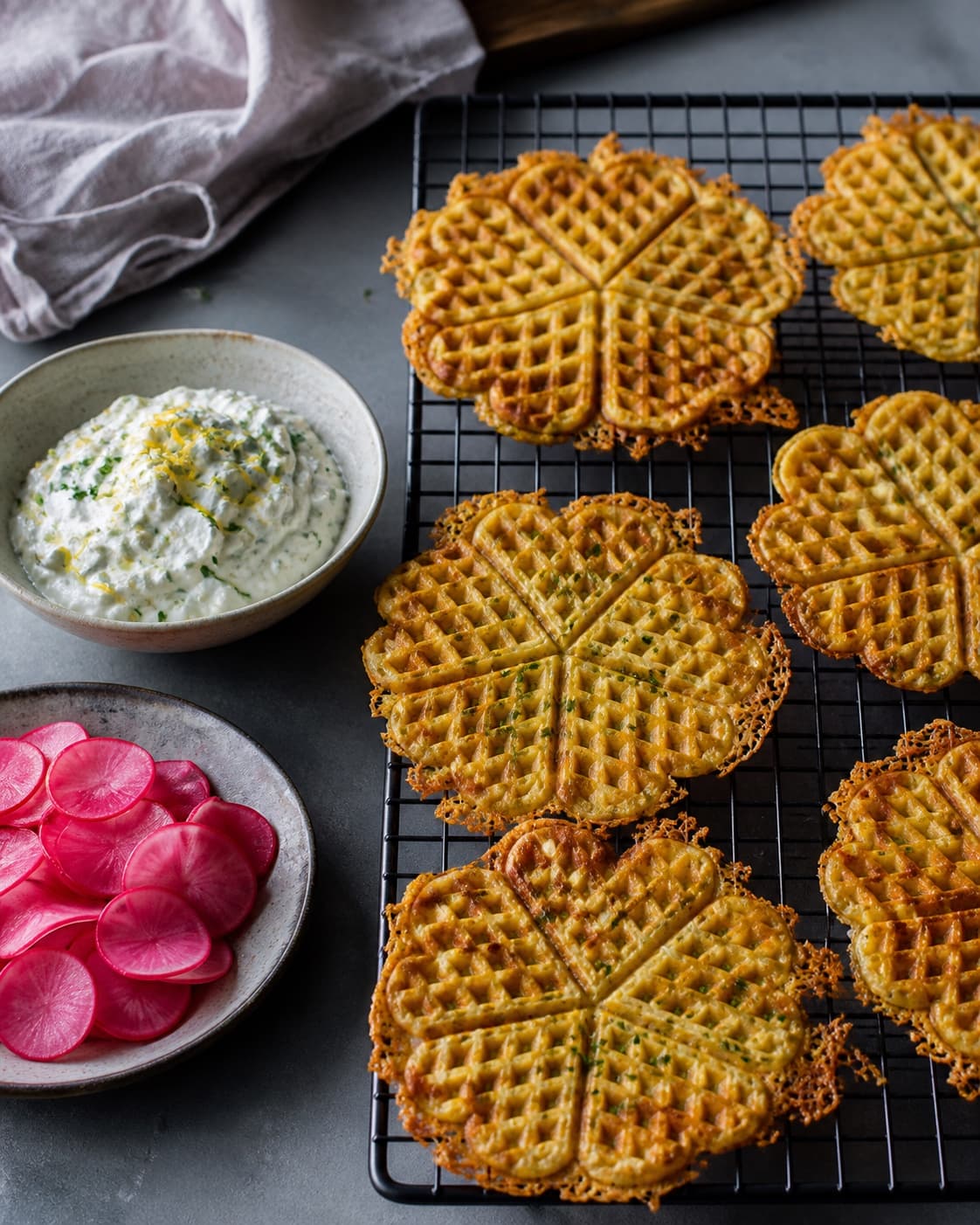 Gyldne femhjertevafler køler enkeltvis på rist med kold citronskyr og drænede rosa radiser serveret helt separat