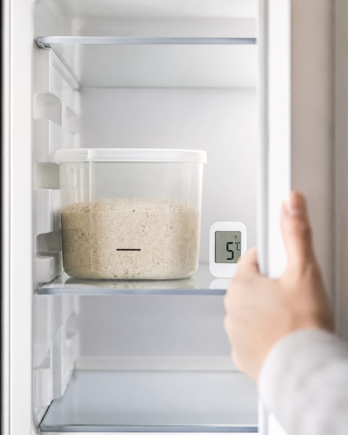 Tæt lukket havredej står luftig og cirka 25 procent over startmarkeringen i et rent køleskab, mens køletemperaturen vises som 5 °C