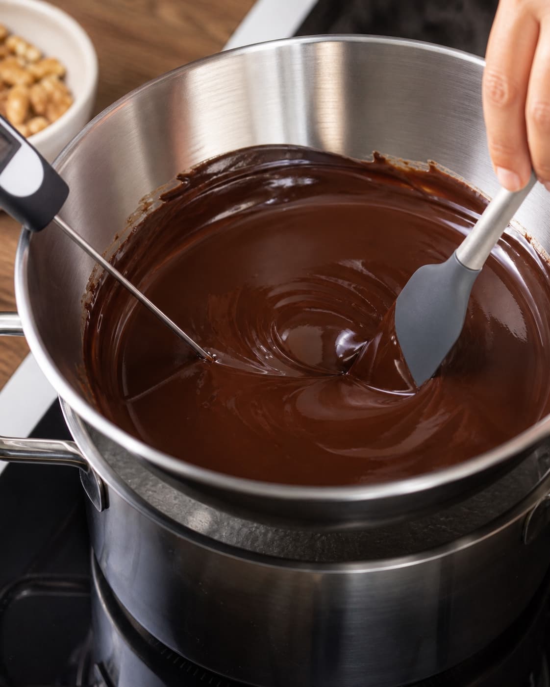 Mørk chokolade og smør røres til en helt blank glat base over et roligt vandbad mens temperaturen kontrolleres i skålen