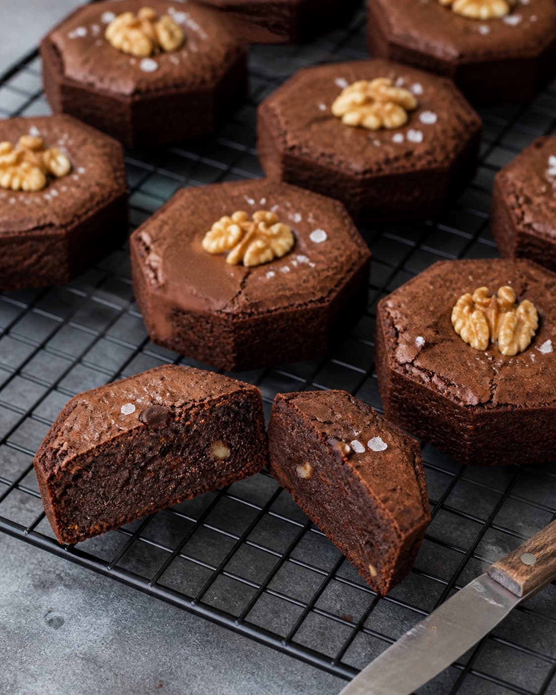 Helt afkølede brownies holder skarpe ottekantede sider og et rent snit viser tæt fugtig men fuldt sat krumme med nødder