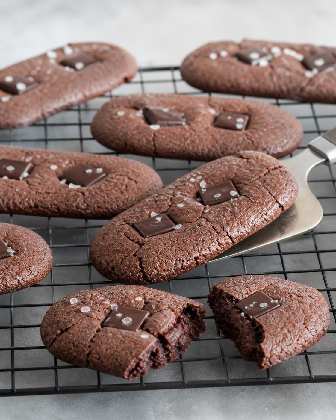 Helt afkølede aflange brownie cookies løftes uden bøjning og en brækket testcookie viser en fugtig sej men fuldt sat midte
