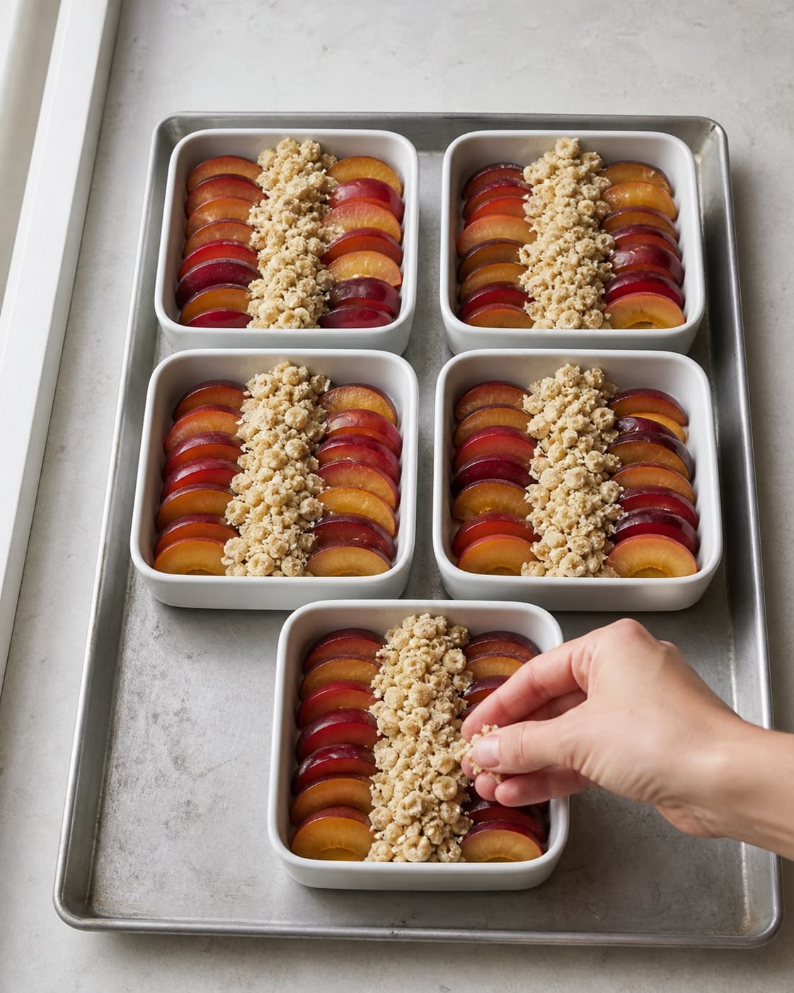 Præcis fem lave firkantede portionsfade har to synlige blommevifter og en smal løs crumblebane i midten med åbne frugtsider