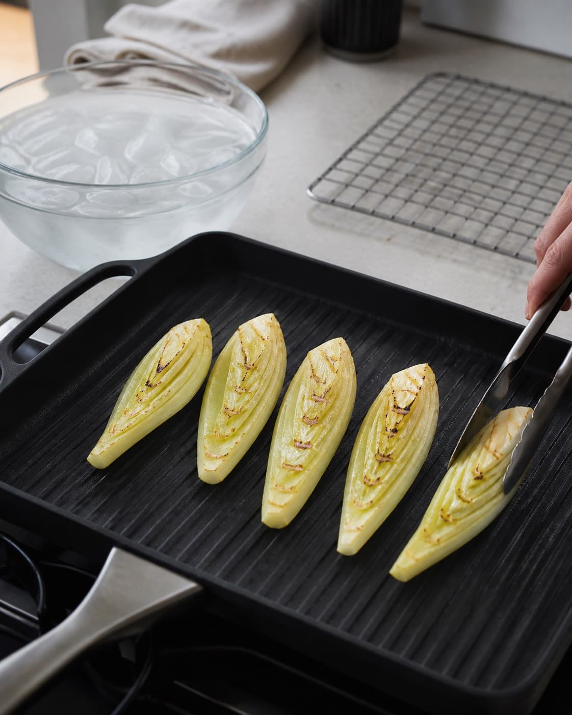Præcis fem blancherede fennikelbåde grilles adskilt med fine bronzefelter, mens den femte vendes med tang og siderne forbliver hele