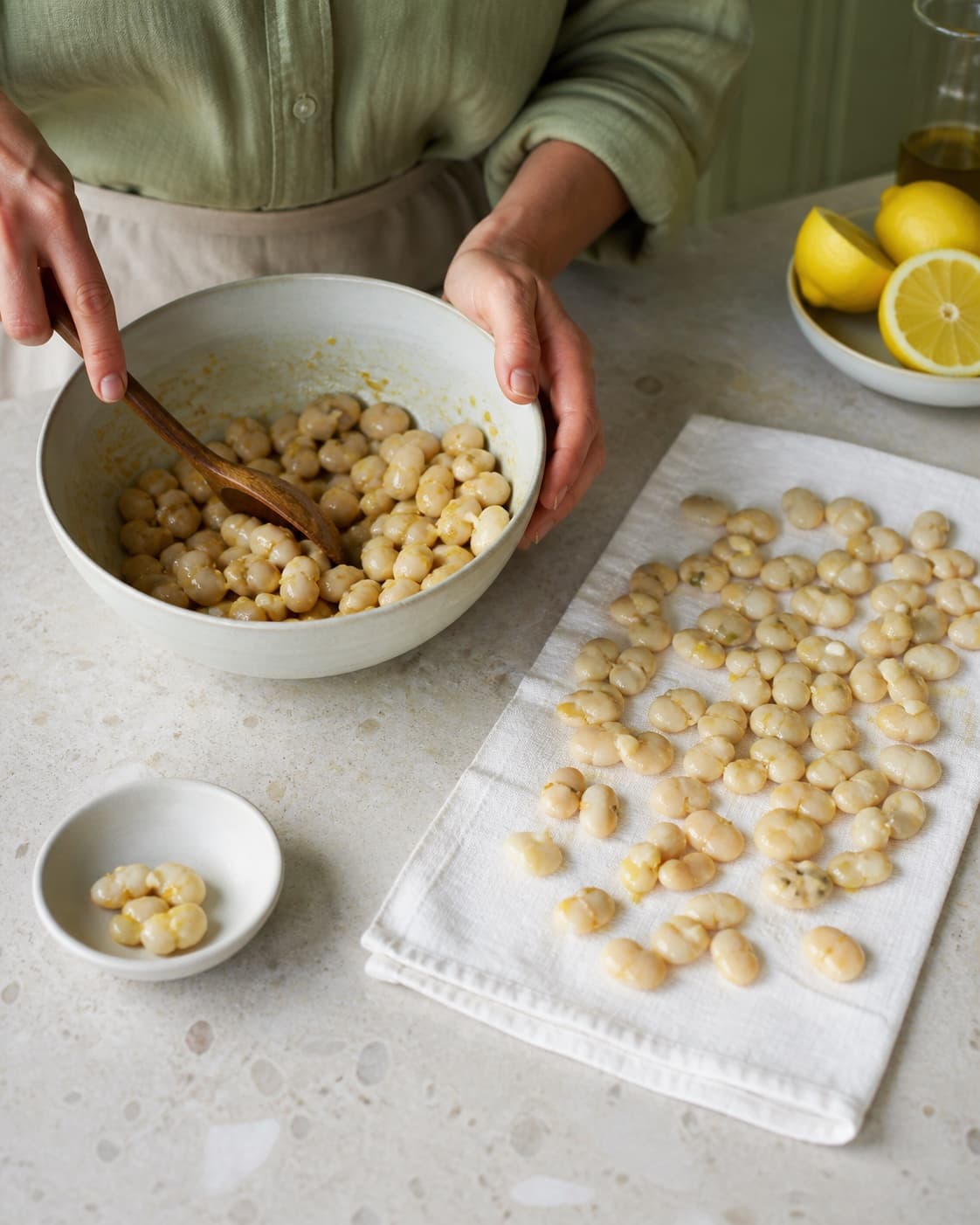 Tørre hele butterbeans vendes nænsomt i en tynd citron-dijonmarinade, mens sprængte bønner sorteres fra på en separat lille skål