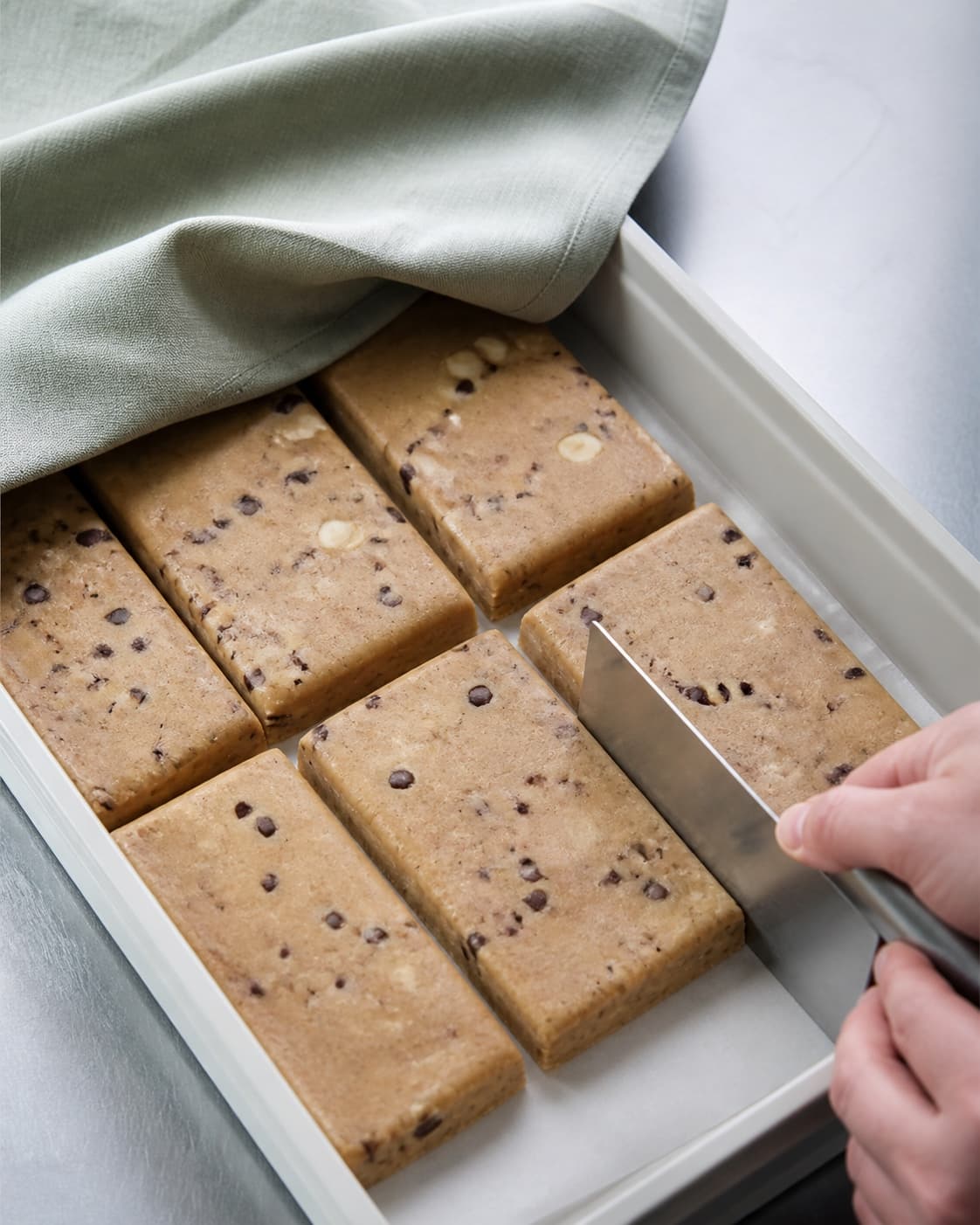 Faste kolde cookiebar-dejstykker ligger tildækket med matte ens flader, rette kanter og ingen smeltet fedtrand