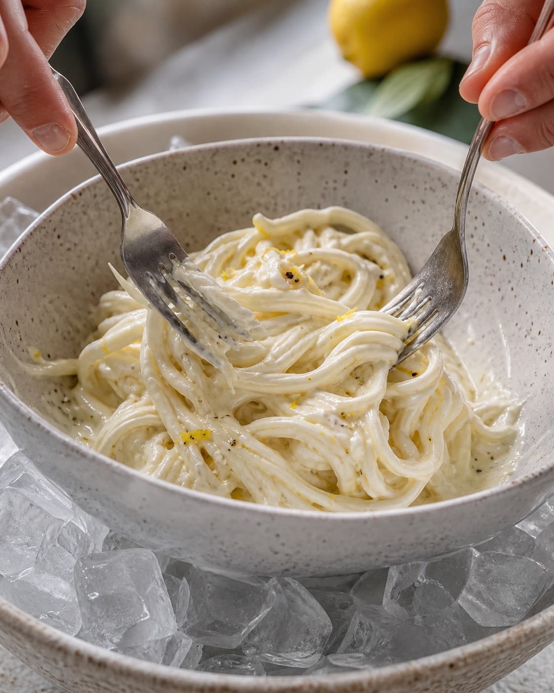 Tydelige mozzarella-fibre foldes forsigtigt med kold citronfløde i en skål over is uden at blive pisket
