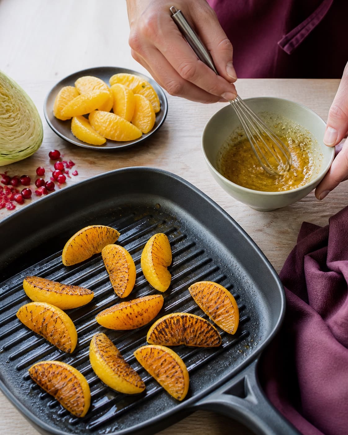 Appelsinfileter får mørke grillstriber på en varm grillpande, mens citrus-sennepsdressing piskes blank i en skål