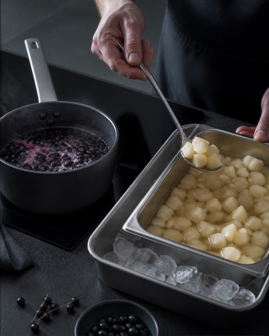 Møre pæretern løftes fra lys citronlage til en beholder over is, mens solbær koger til mørk sauce i en separat gryde