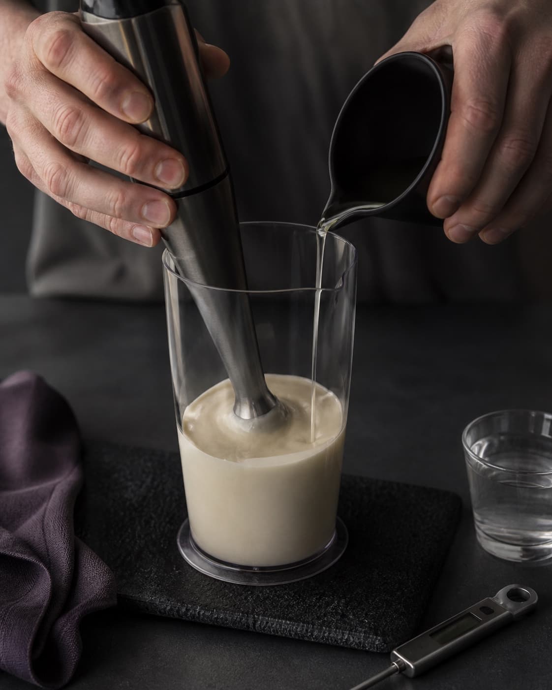 Neutral olie hældes i en meget tynd stråle omkring stavblenderen, mens den lyse mayonnaise bliver tyk og blank