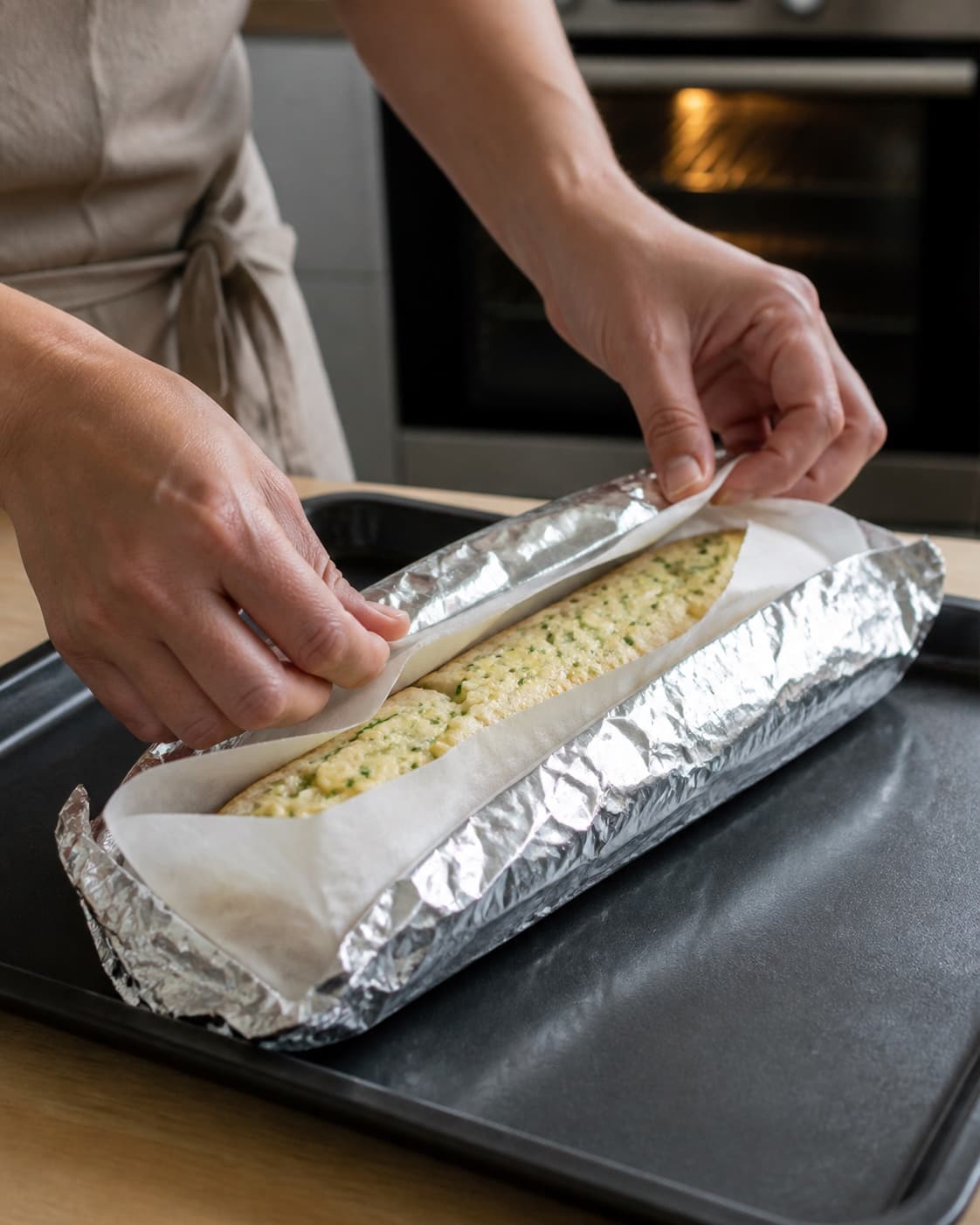 Hvidløgsbrød pakkes i bagepapir og folie før kontrolleret bagning