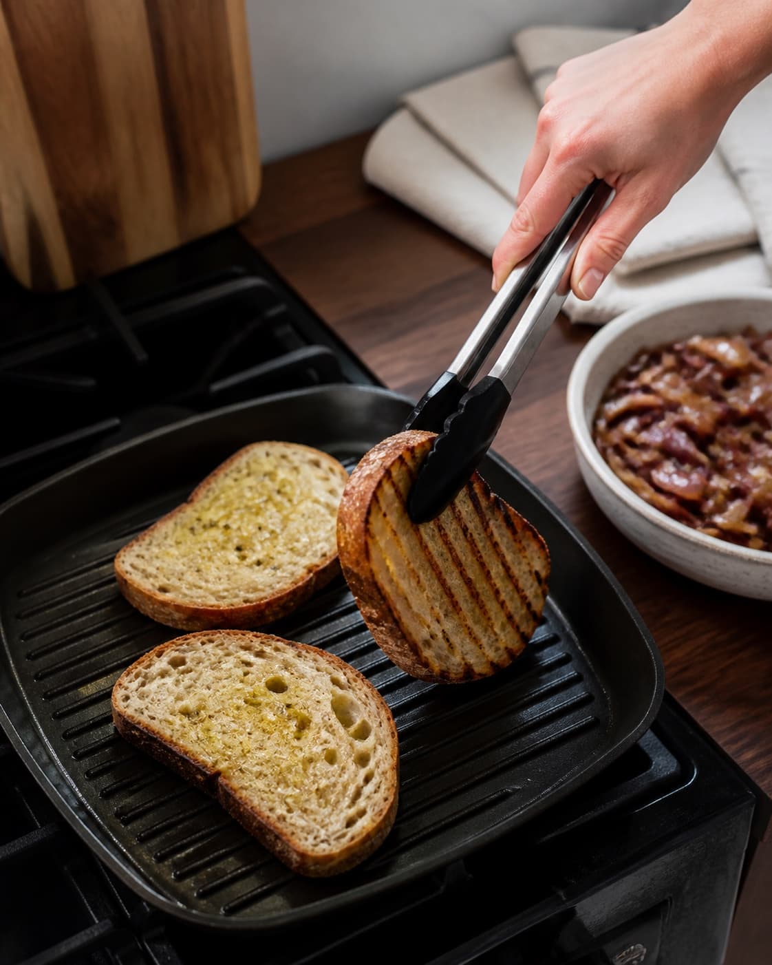 Olieret surdejsbrød vendes på grillpande med tydelige striber