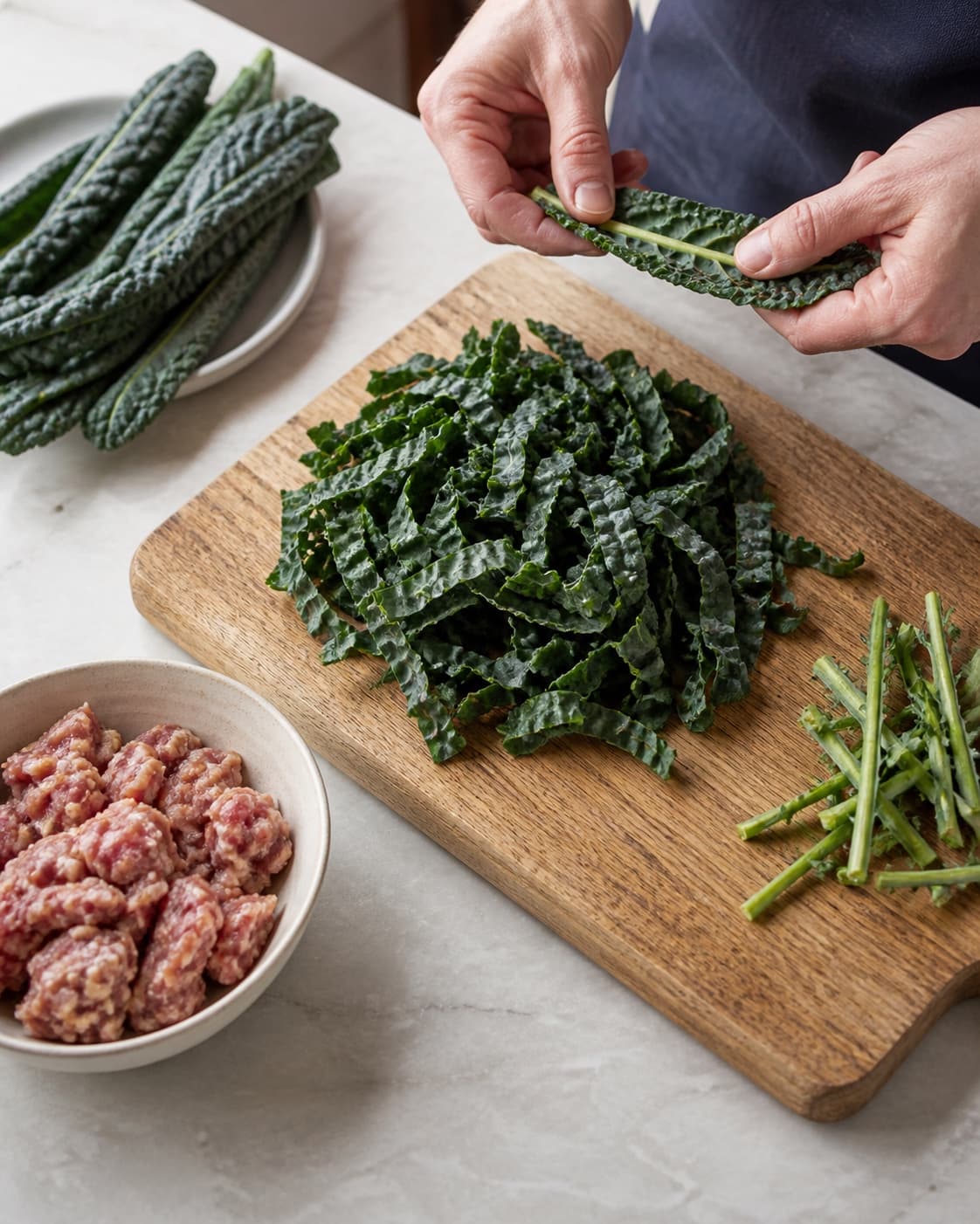 Cavolo nero ribbes og snittes med rå salsiccia separat i en skål
