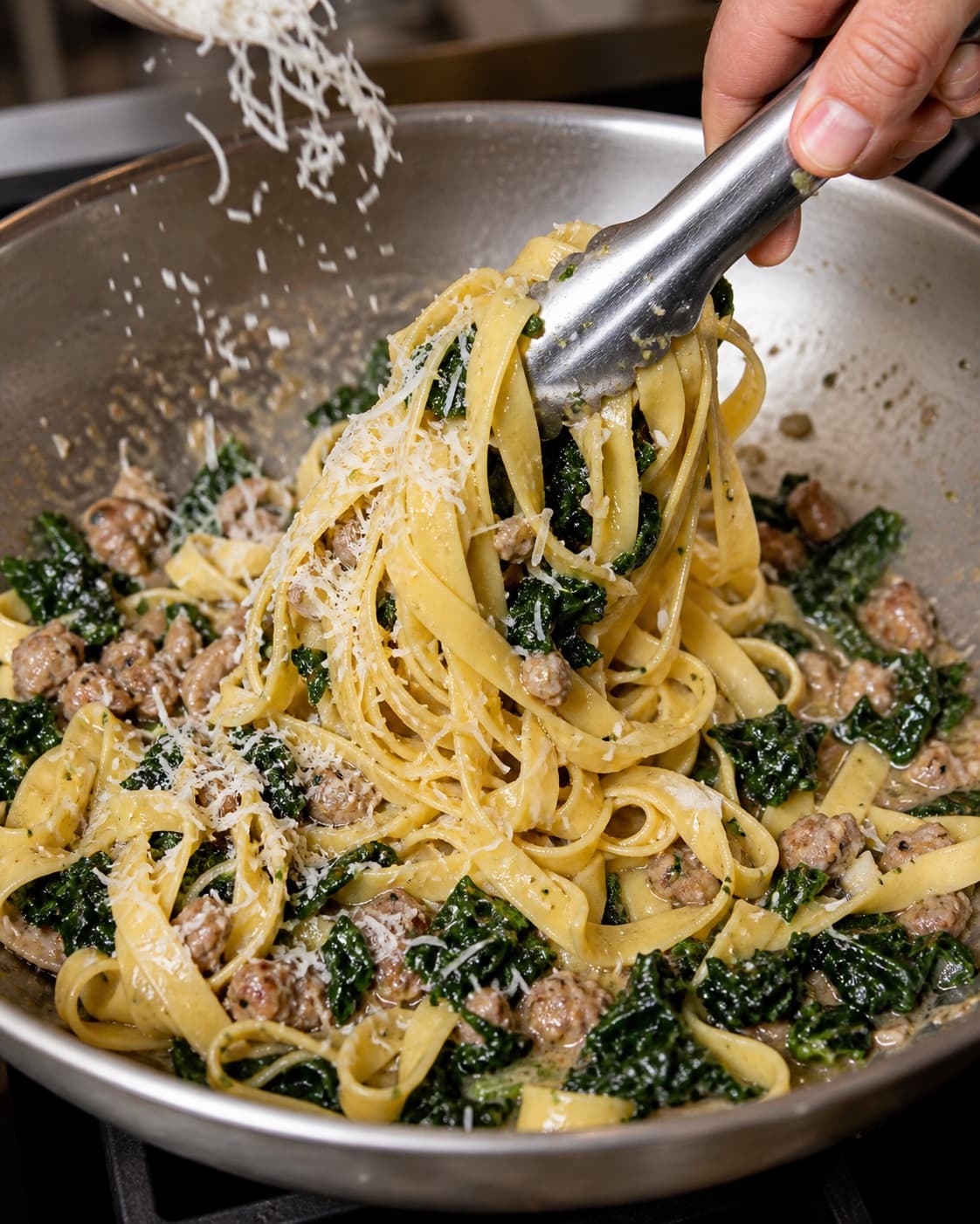 Tagliatelle vendes med salsiccia, cavolo nero, ost og citron i panden
