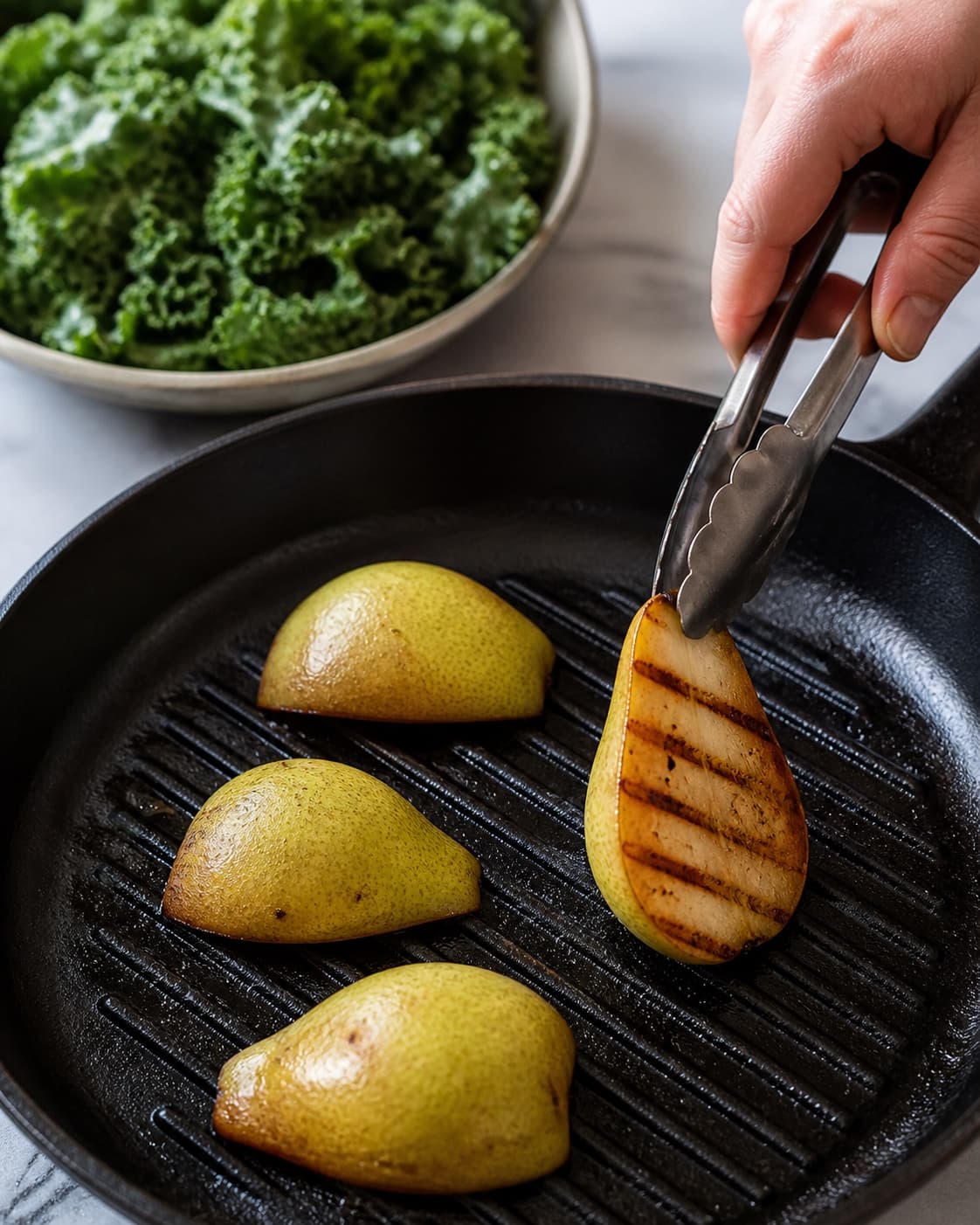 Faste pærekvarte vendes på grillpande med mørke karamelliserede striber