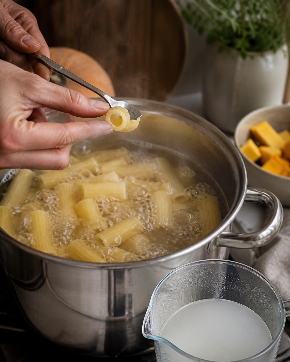 En rigatonitube kontrolleres for al dente kerne, mens stivelsesvand gemmes