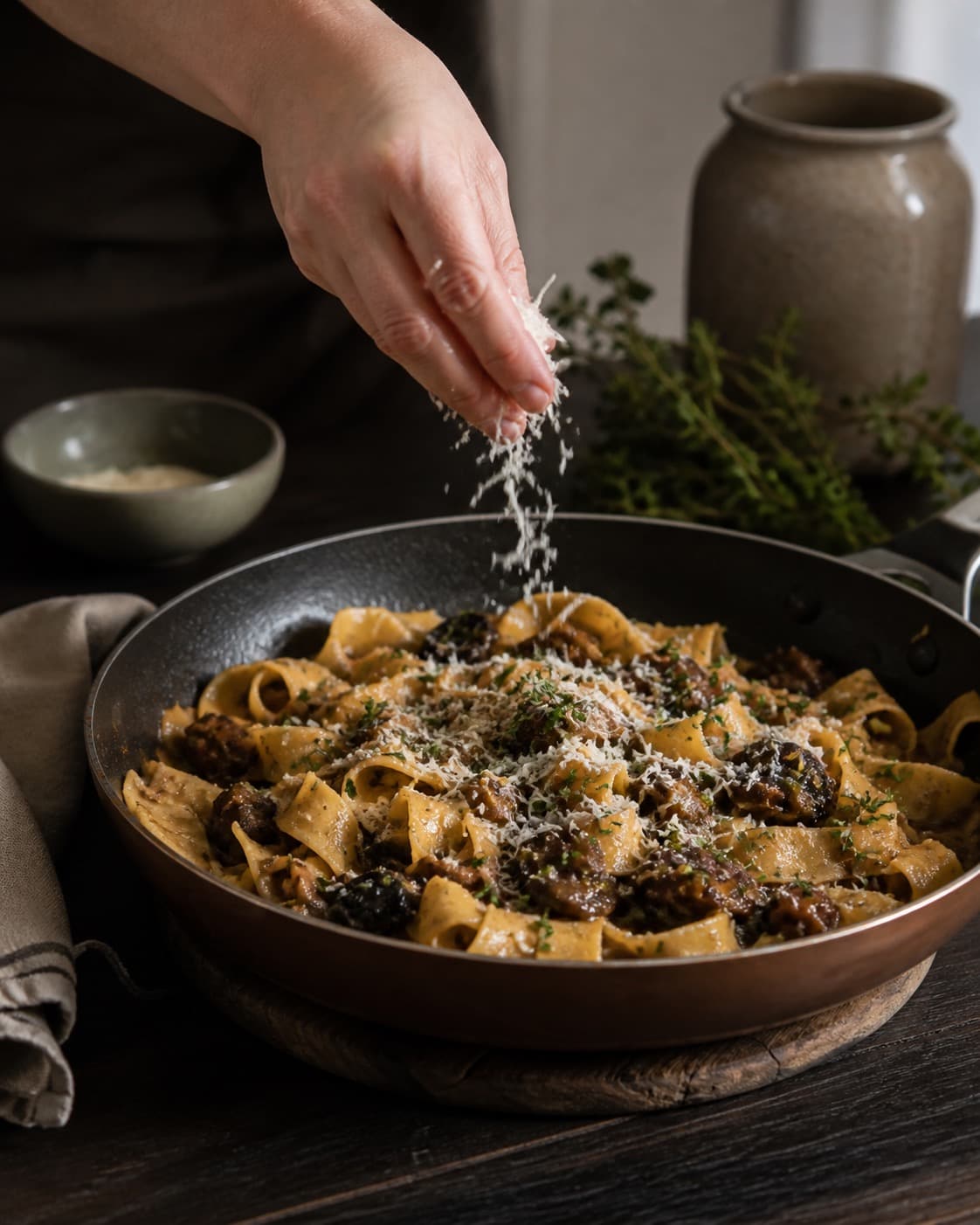 pappardelle med svamperagout får timian og parmesan lige før servering under tilberedningen af pappardelle med svamperagout, selleri og timian