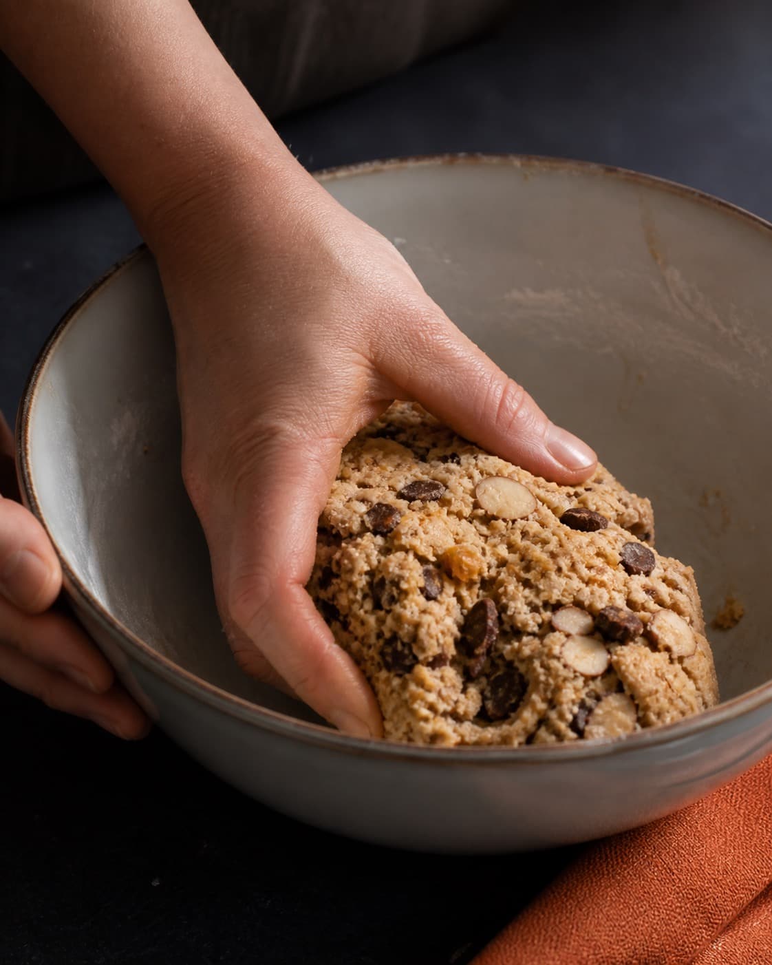 den faste æggedej samles nænsomt til biscottistængerne i en røreskål under tilberedningen af biscotti med mandel, chokolade og appelsinfennikel