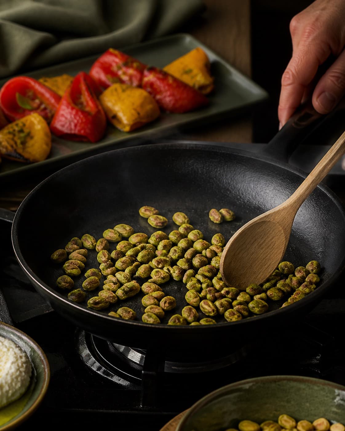 Sprødt tilbehør ristes gyldent til de grillede peberfrugter under tilberedningen af grillede peberfrugter med ricotta og pistacie