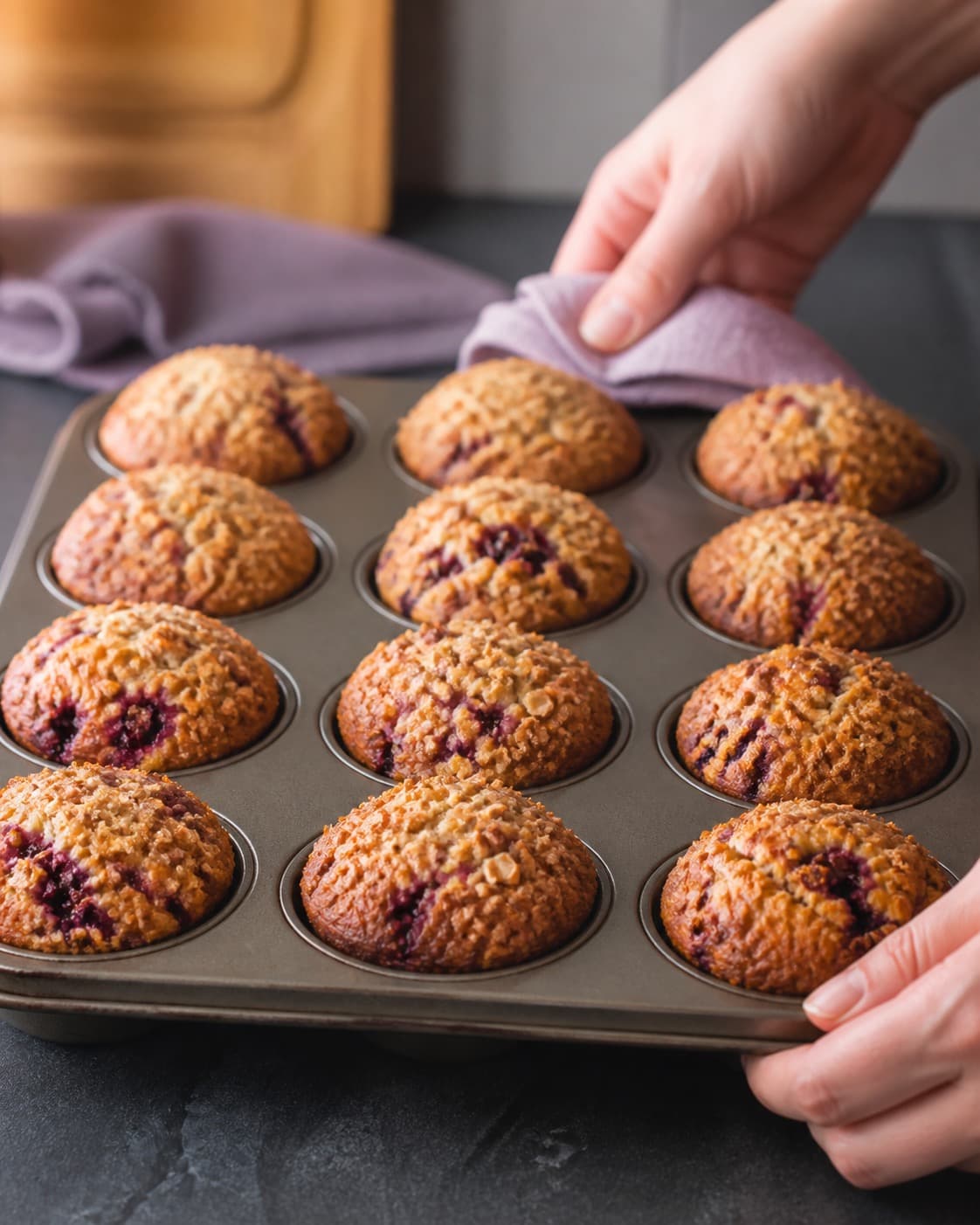 brombærmuffinsene bager gylden i formen med synlig fast midte under tilberedningen af brombærmuffins med citron, hvid chokolade og crumble