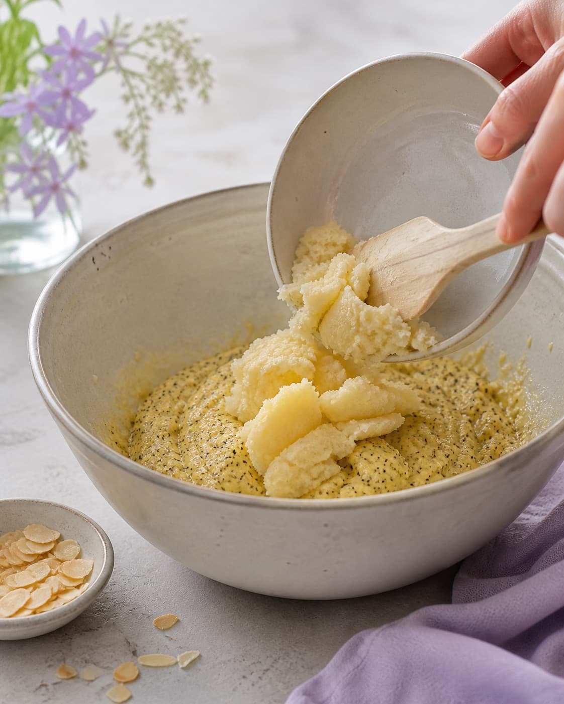 marcipan-citrondejen samles nænsomt til citronkagen i en røreskål under tilberedningen af citronkage med birkes, marcipan og skyrfrosting