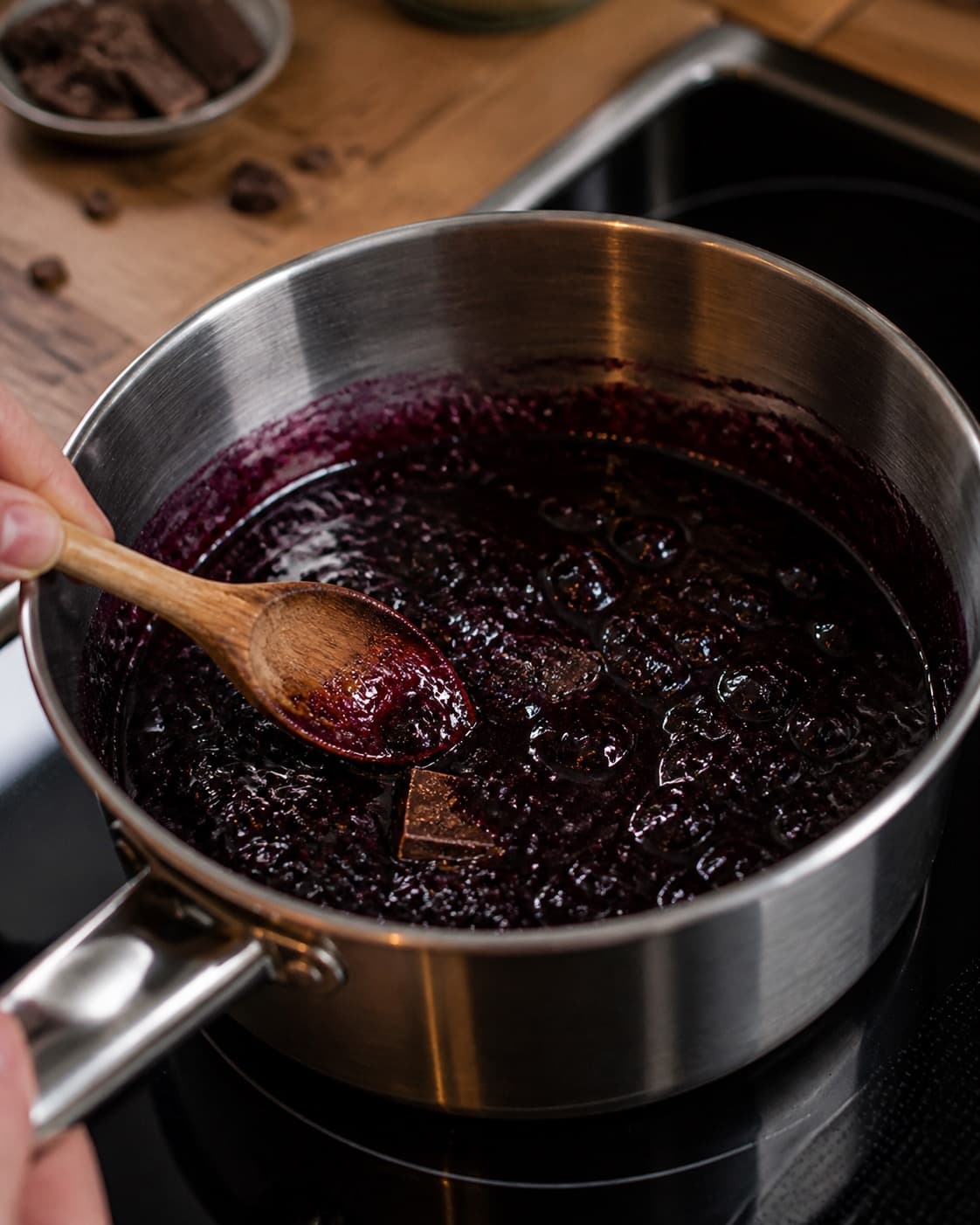 solbærkompot og chokoladestykker koges nænsomt til et blankt frugtelement under tilberedningen af solbæris med kompot, mørk chokolade og kardemomme