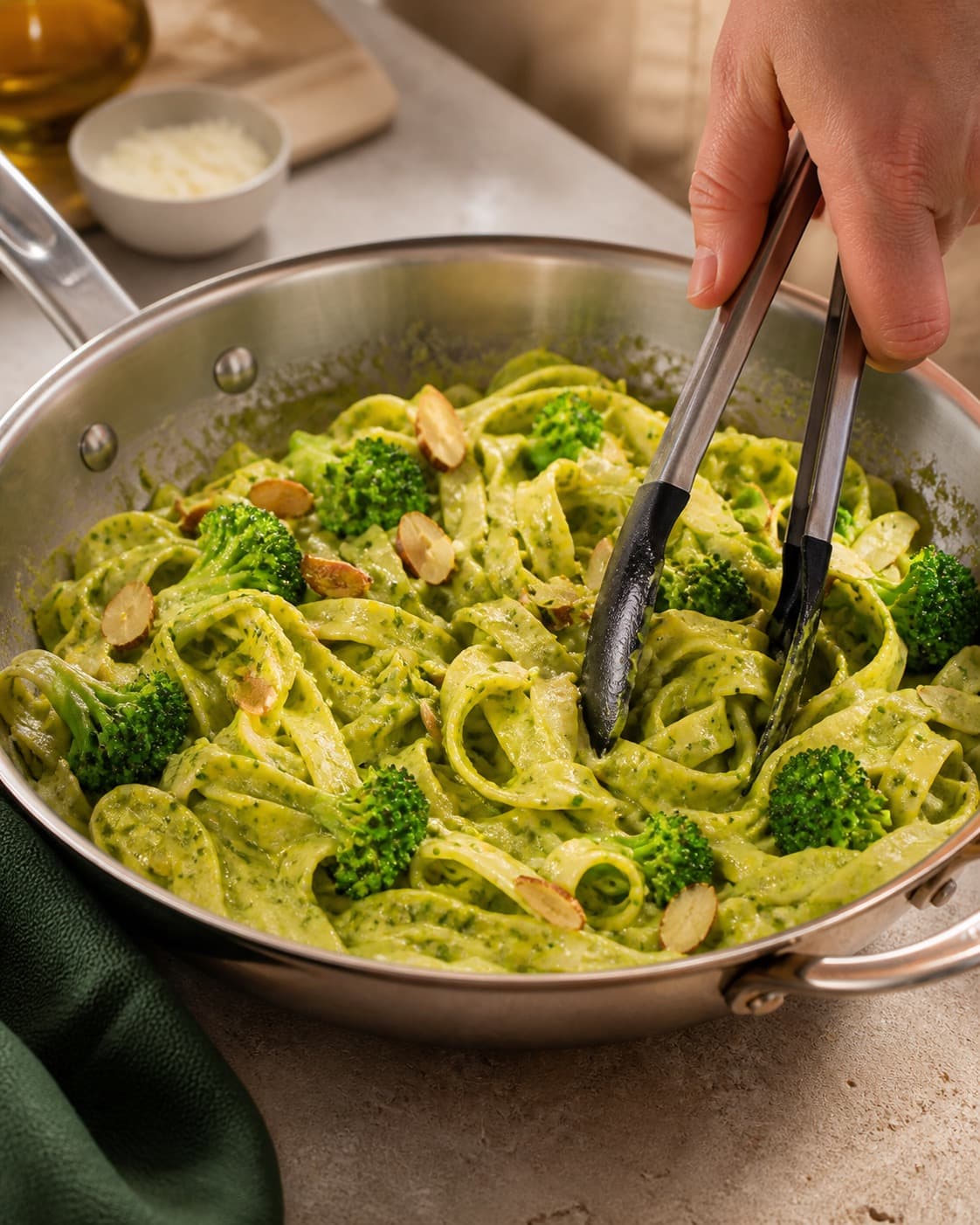 broccoli-basilikumpestoen bygges i en bred pande med blank smagsbase under tilberedningen af pasta pesto med broccoli, mandel og citron