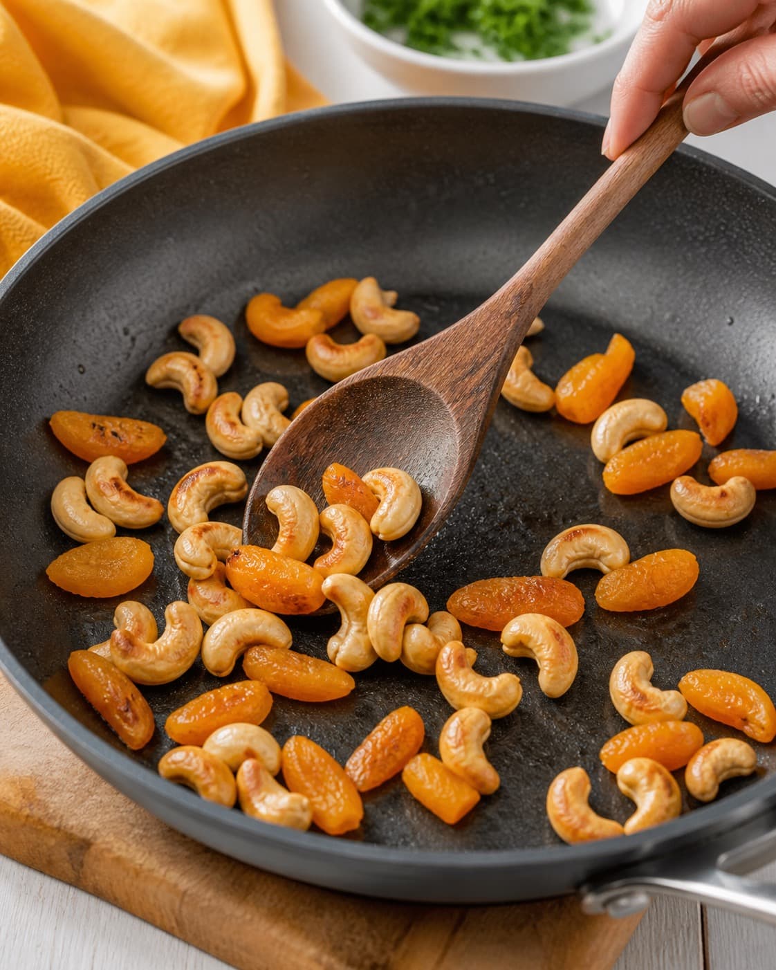 Sprødt tilbehør ristes gyldent til blomkålscouscousen under tilberedningen af blomkålscouscous med granatæble, cashew og abrikos