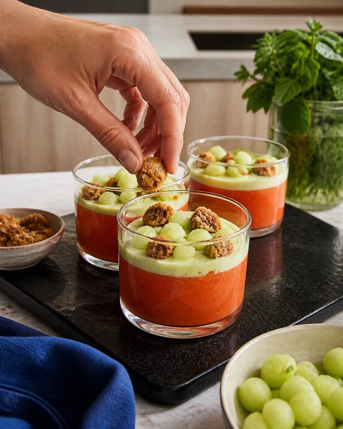 ferskengazpachoen bygges i tydelige lag af frugt creme og knas under tilberedningen af ferskengazpacho med peberfrugt og rugcroutoner