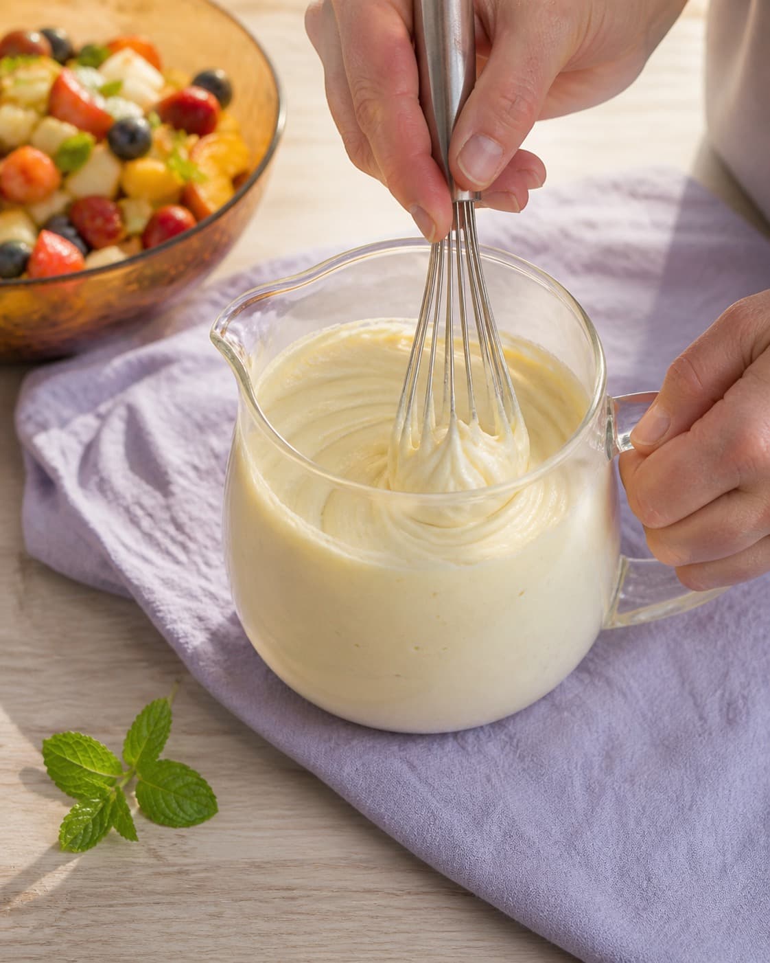 citrus-råcremen piskes til bløde glatte toppe under tilberedningen af frugtsalat med citrus-råcreme og mandelknas