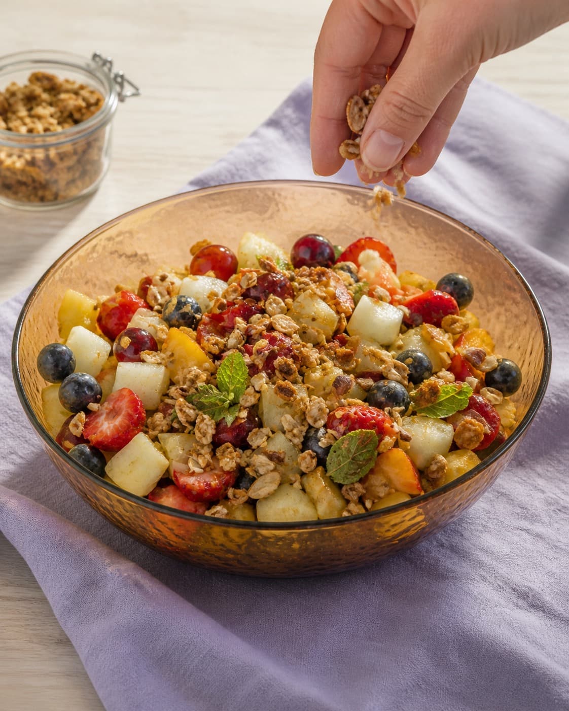 frugtsalaten afsluttes kold med mandel-havreknas under tilberedningen af frugtsalat med citrus-råcreme og mandelknas