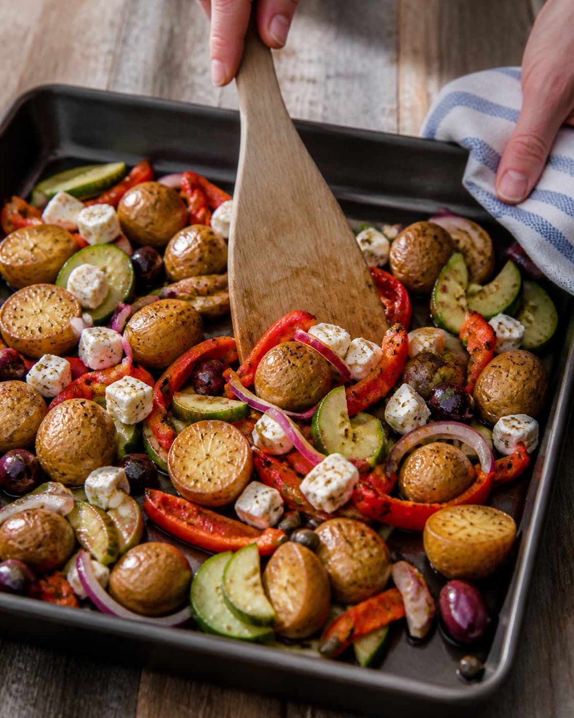 Sprødt tilbehør ristes gyldent til den græske kartoffelsalat under tilberedningen af græsk kartoffelsalat med feta, peberfrugt og kapers