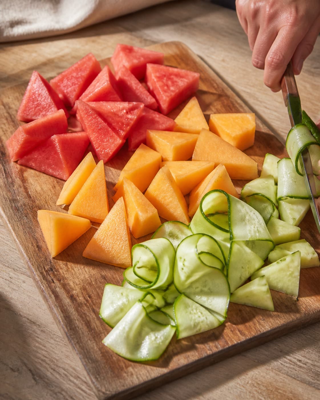 vandmelon, honningmelon og agurk klargøres ensartet til melonsalaten under tilberedningen af melonsalat med chili, mynte, feta og græskarkerner