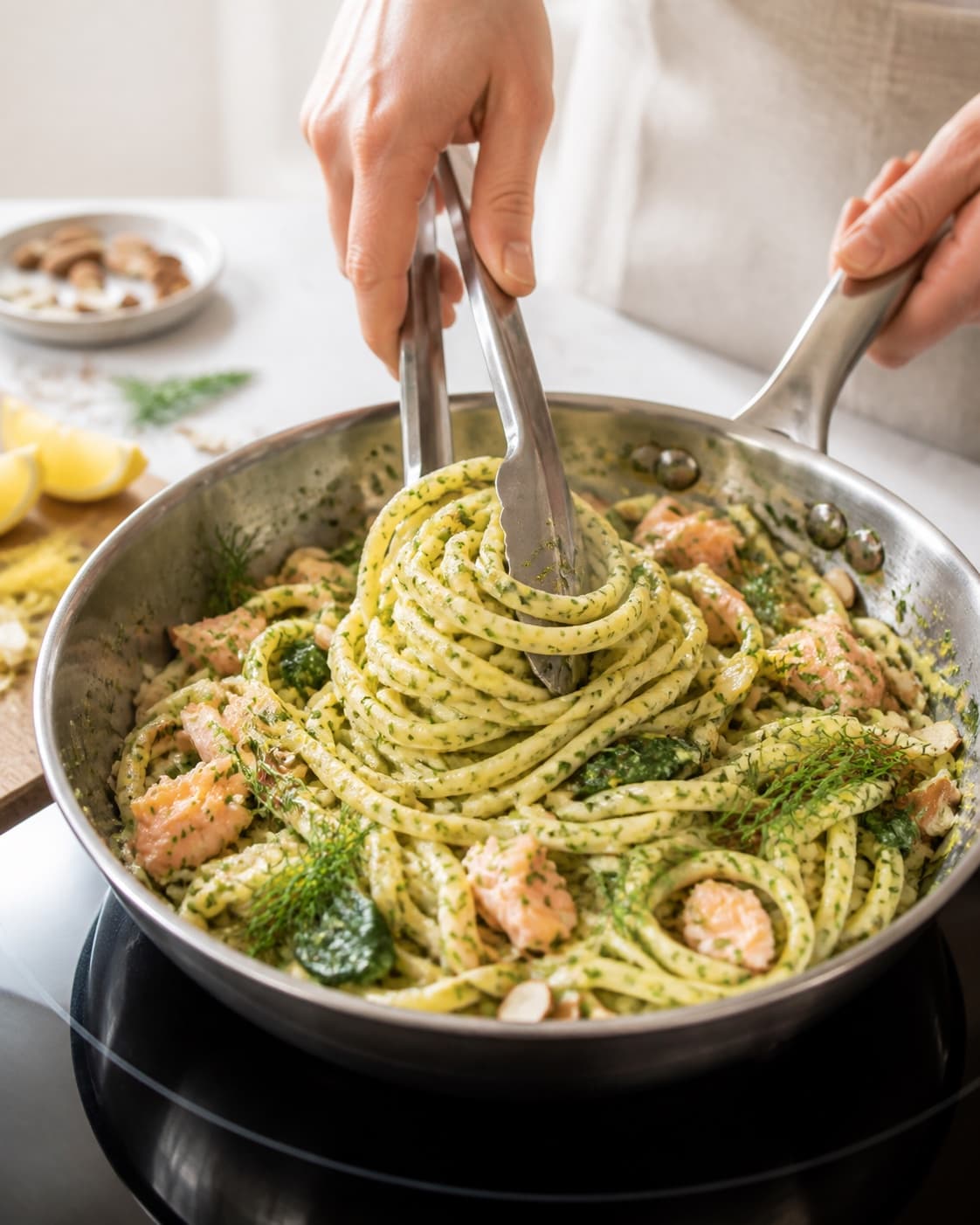 Pasta svinges blank med dildpesto, spinat og citron under tilberedningen af tagliatelle med varmrøget laks, dildpesto og citron