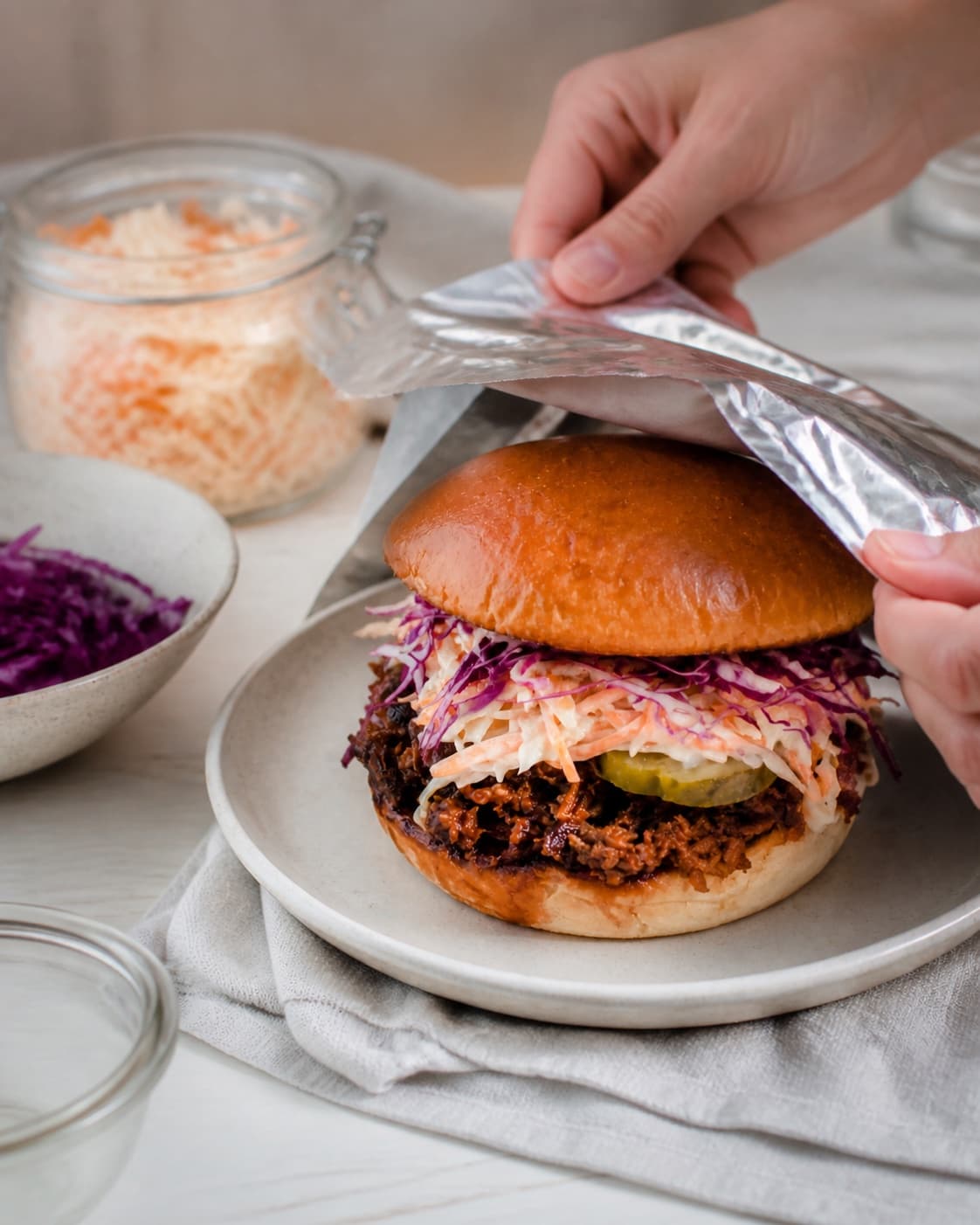 pulled pork-sandwichen hviler mens en blank sky samles under tilberedningen af pulled pork-sandwich med æbleslaw og sennepssky