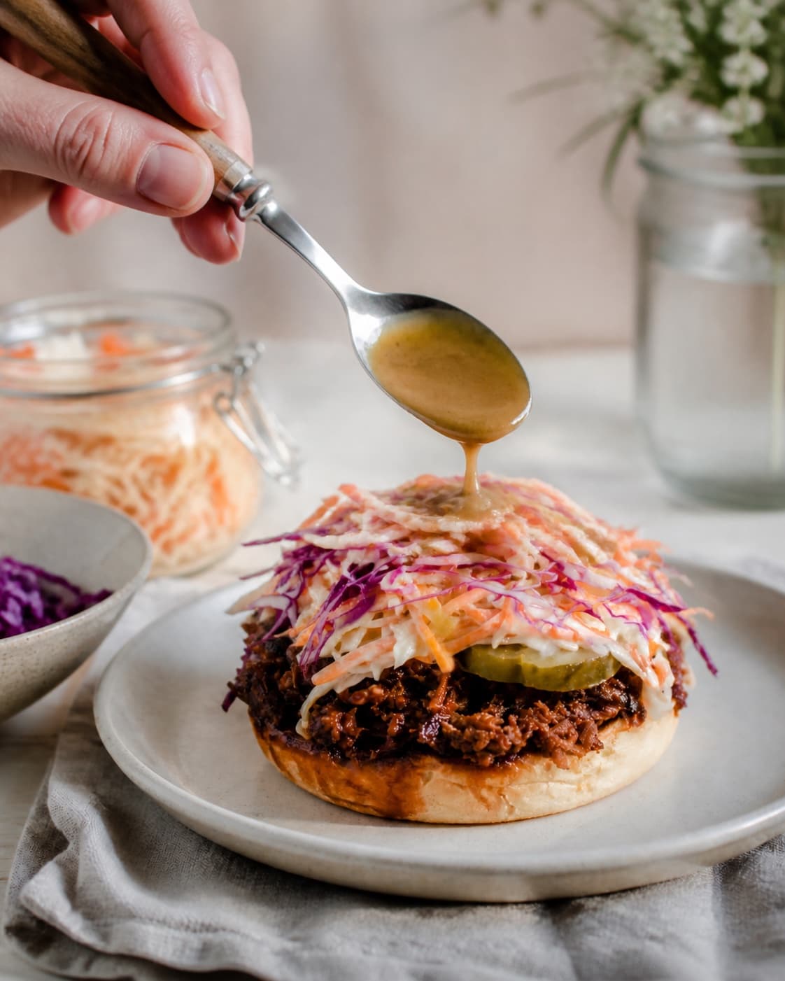 pulled pork-sandwichen anrettes med sprød æbleslaw og reduceret sennepssky under tilberedningen af pulled pork-sandwich med æbleslaw og sennepssky