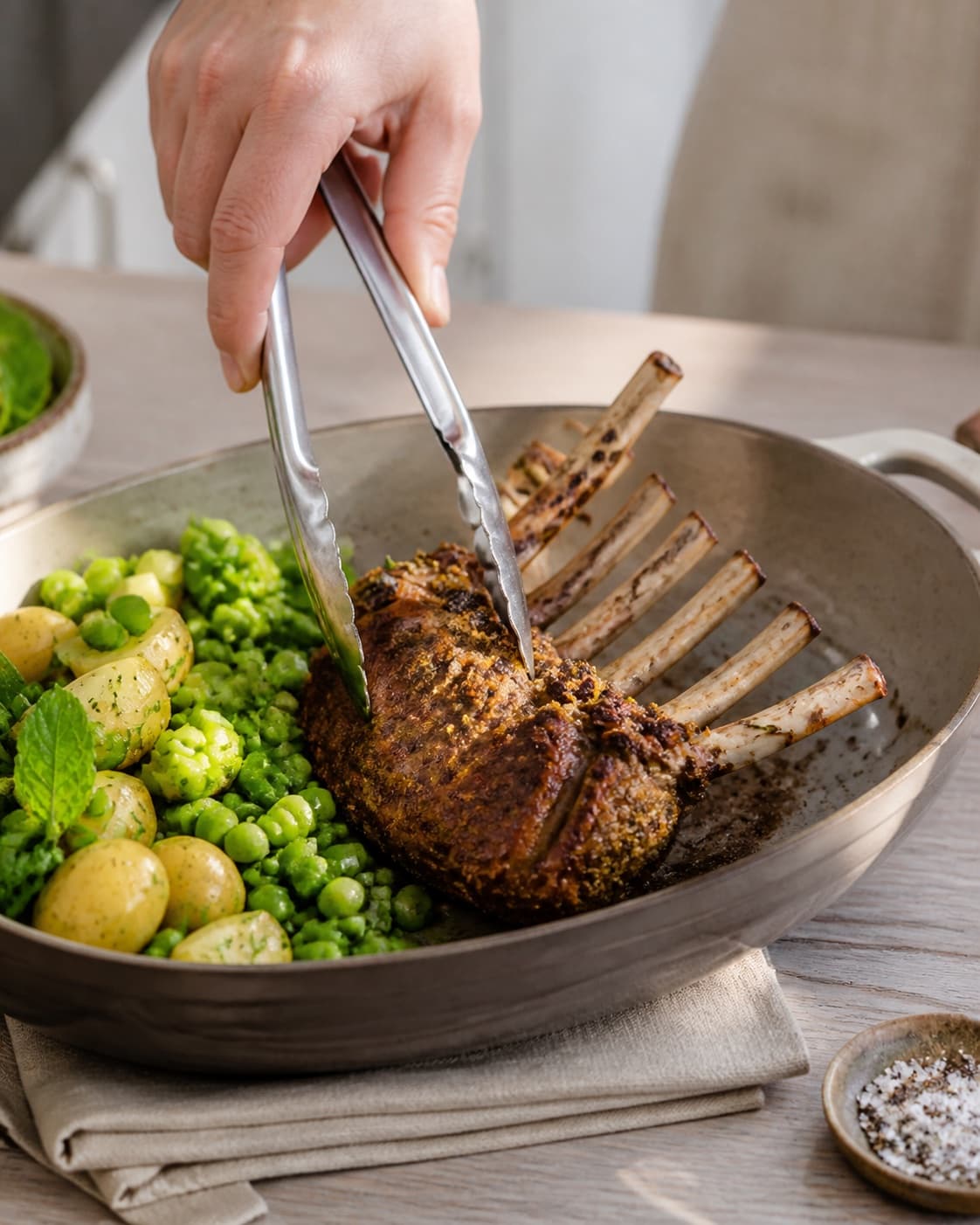 lammekronen steger gylden med tydelige karamelliserede kanter under tilberedningen af urtestegt lammekrone med grøn kartoffelsalat og mynte