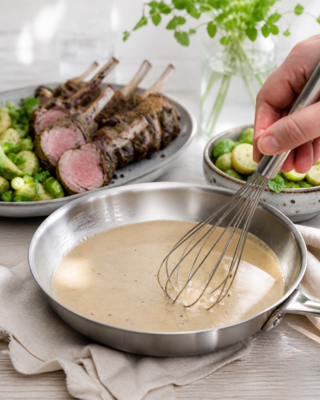 lammekronen hviler mens en blank sky samles under tilberedningen af urtestegt lammekrone med grøn kartoffelsalat og mynte