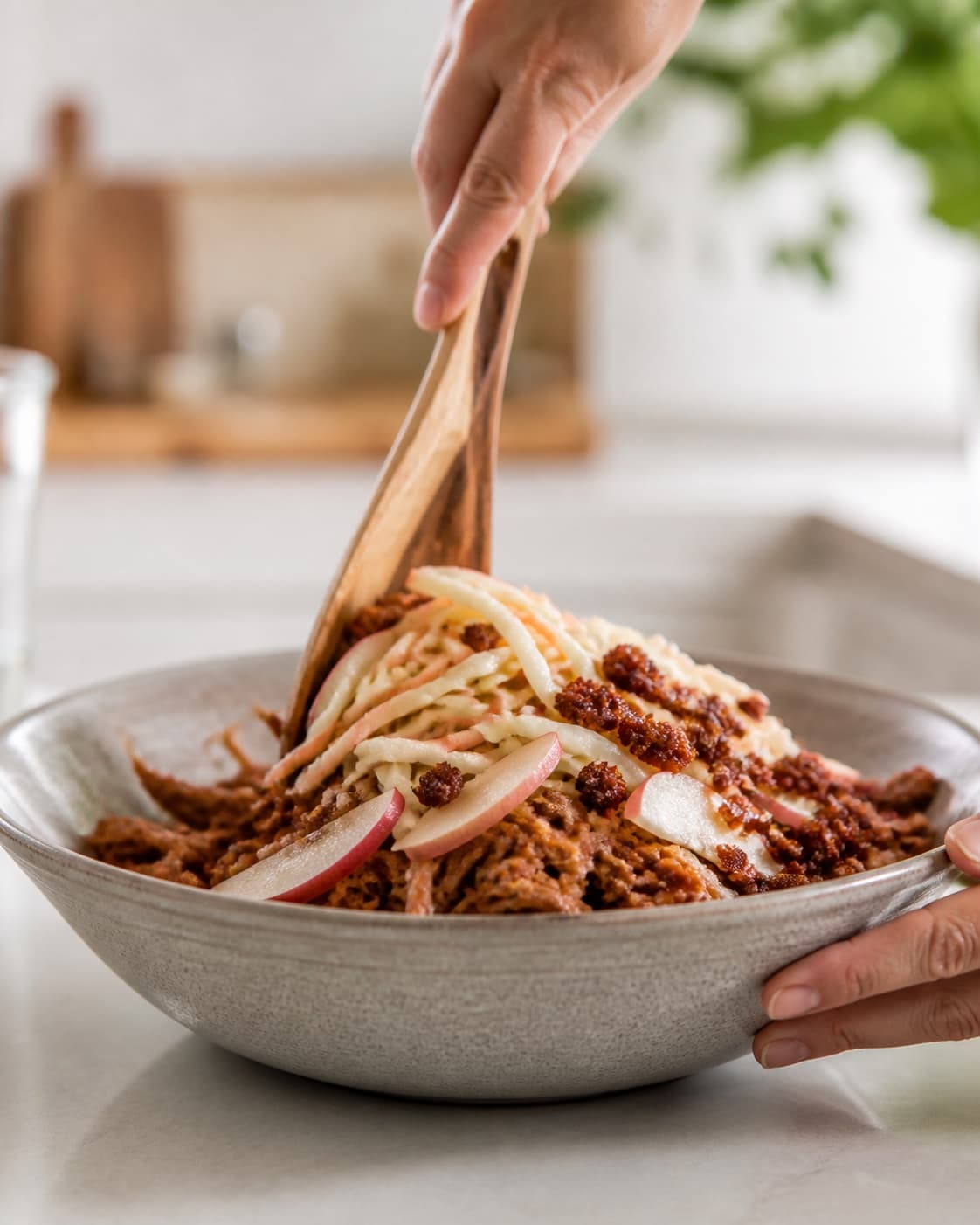 varmt kød, kål og æble klargøres ensartet til pulled pork-burgerne under tilberedningen af pulled pork-burger med kålslaw, æble og rugbrødsknas
