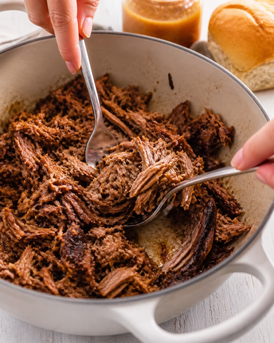 pulled porken steger gylden med tydelige karamelliserede kanter under tilberedningen af langtidsstegt pulled pork med æblemost og fennikelfrø
