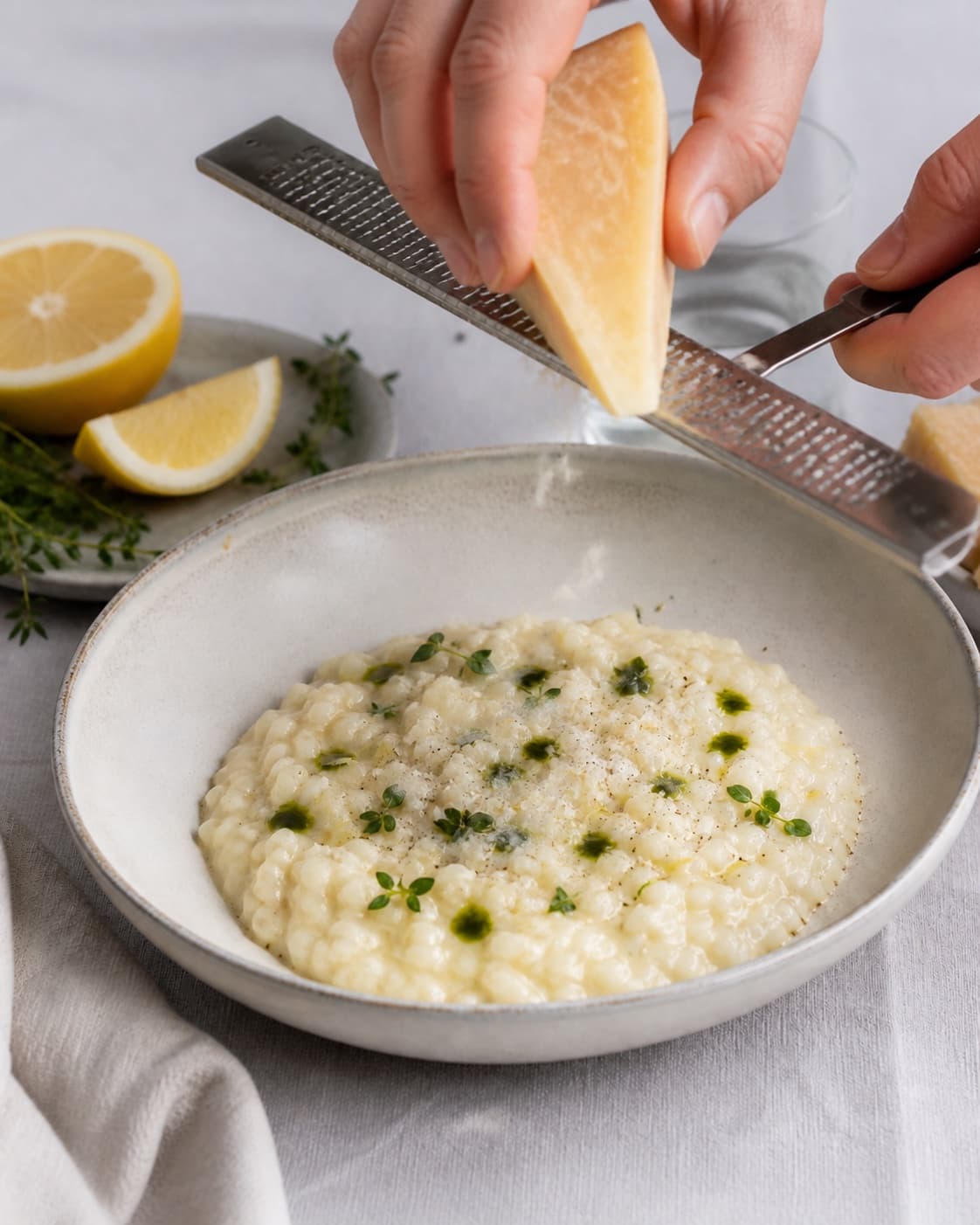 sæsonrisottoen afsluttes med parmesan, citron og grøn urteolie under tilberedningen af sæsonrisotto med citron, parmesan og urteolie