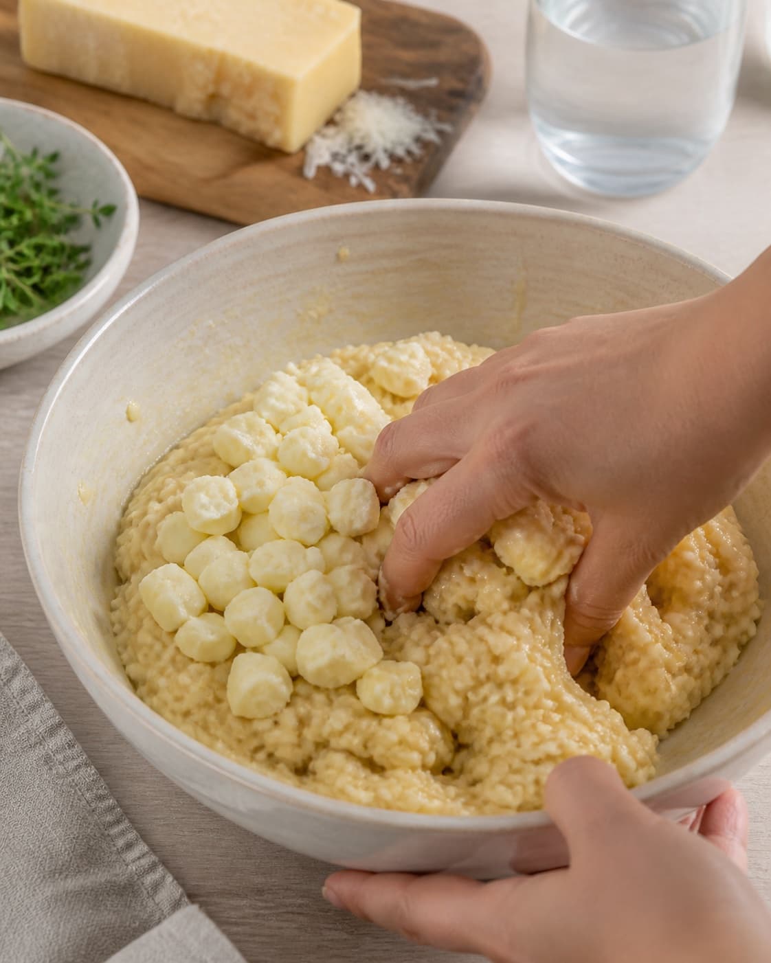 kold risotto med mozzarellakerne blandes til en fast masse til risottodellerne under tilberedningen af sprøde risottodeller med mozzarella og tomatdip