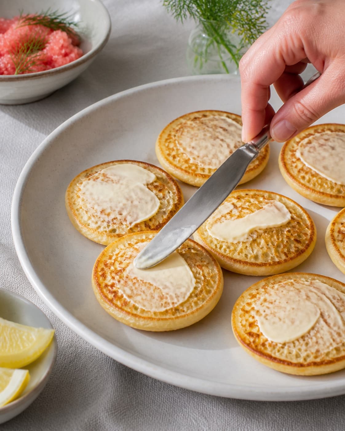 blinisene dækkes jævnt med et tyndt lag smør under tilberedningen af blinis med stenbiderrogn, dild og citroncreme