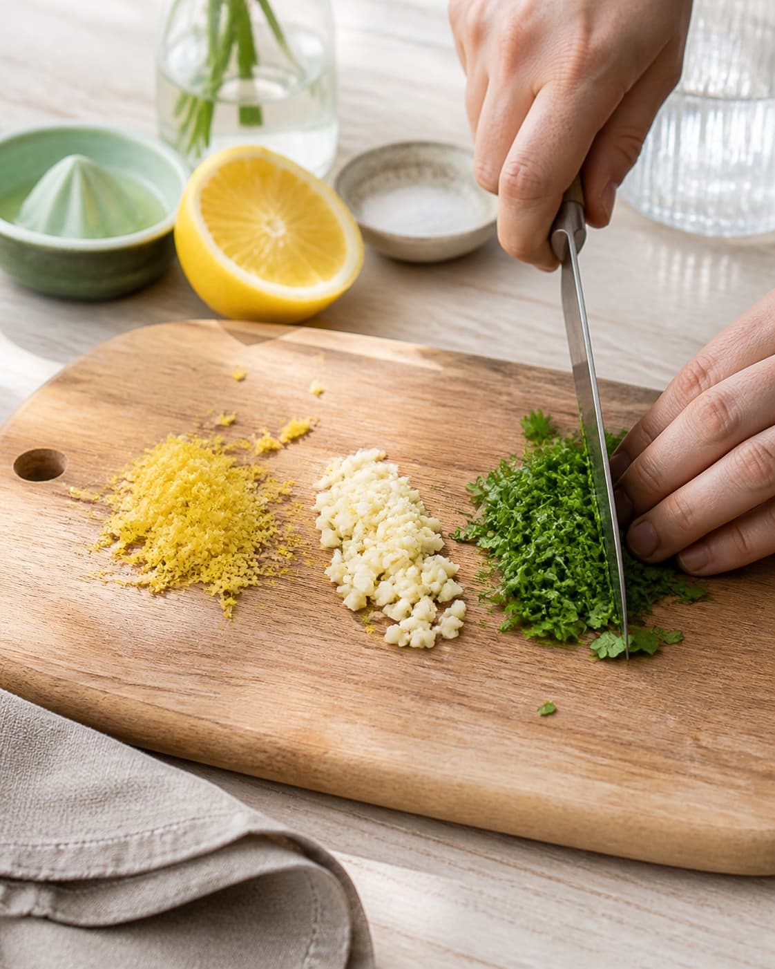 citronskal, hvidløg og persille skæres ensartet til tahindressingen under tilberedningen af tahindressing med citron, yoghurt og spidskommen