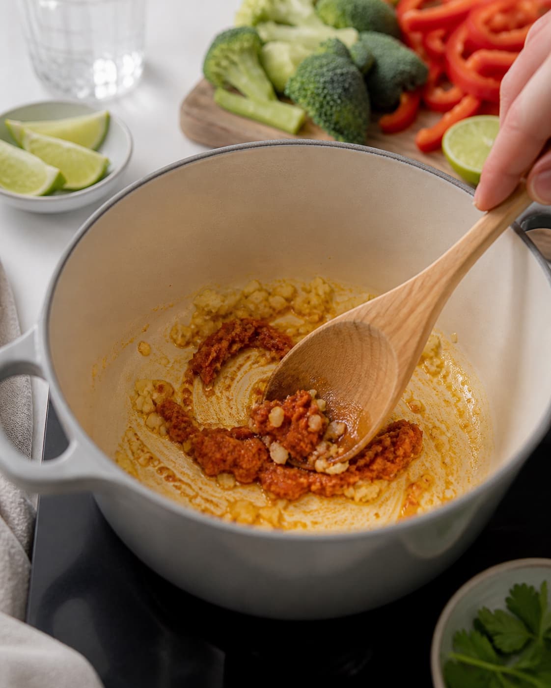 ingefær og rød karrypasta svedes blankt i en tykbundet gryde under tilberedningen af karrysuppe med kylling, kokos og sprøde grøntsager