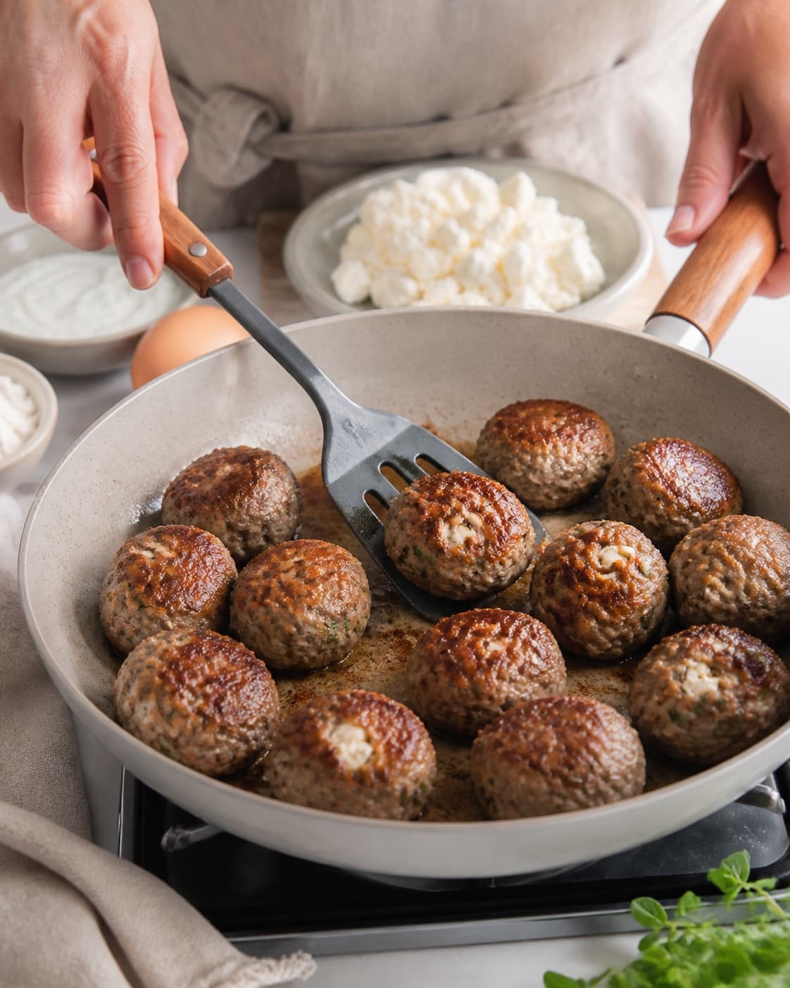 græske frikadeller med feta frying to an even golden crust in a pan under tilberedningen af græske frikadeller med feta