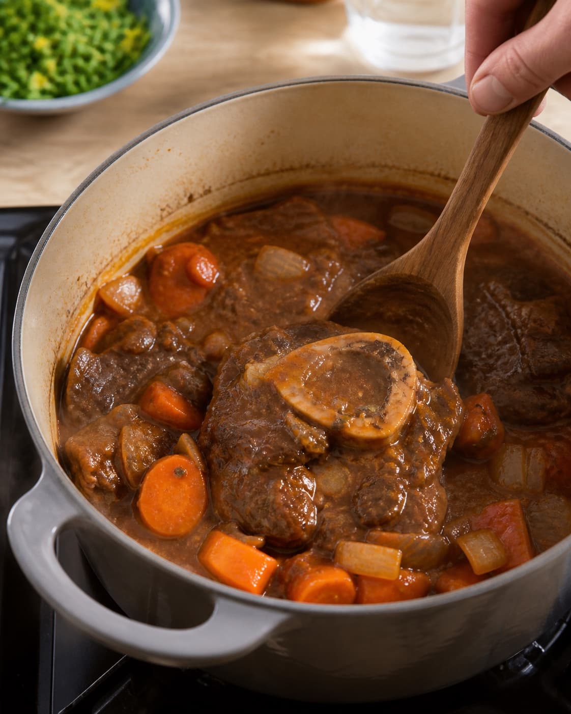 osso buco med kartoffelmos og gremolata gently simmering with visible ingredients under tilberedningen af osso buco med kartoffelmos og gremolata