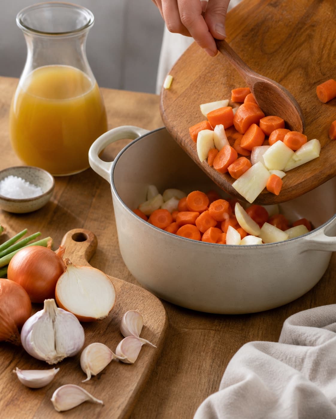 Mise en place for gulerodssuppe with gulerødder, zittauerløg, hvidløg, grøntsags- eller kødfond under tilberedningen af gulerodssuppe